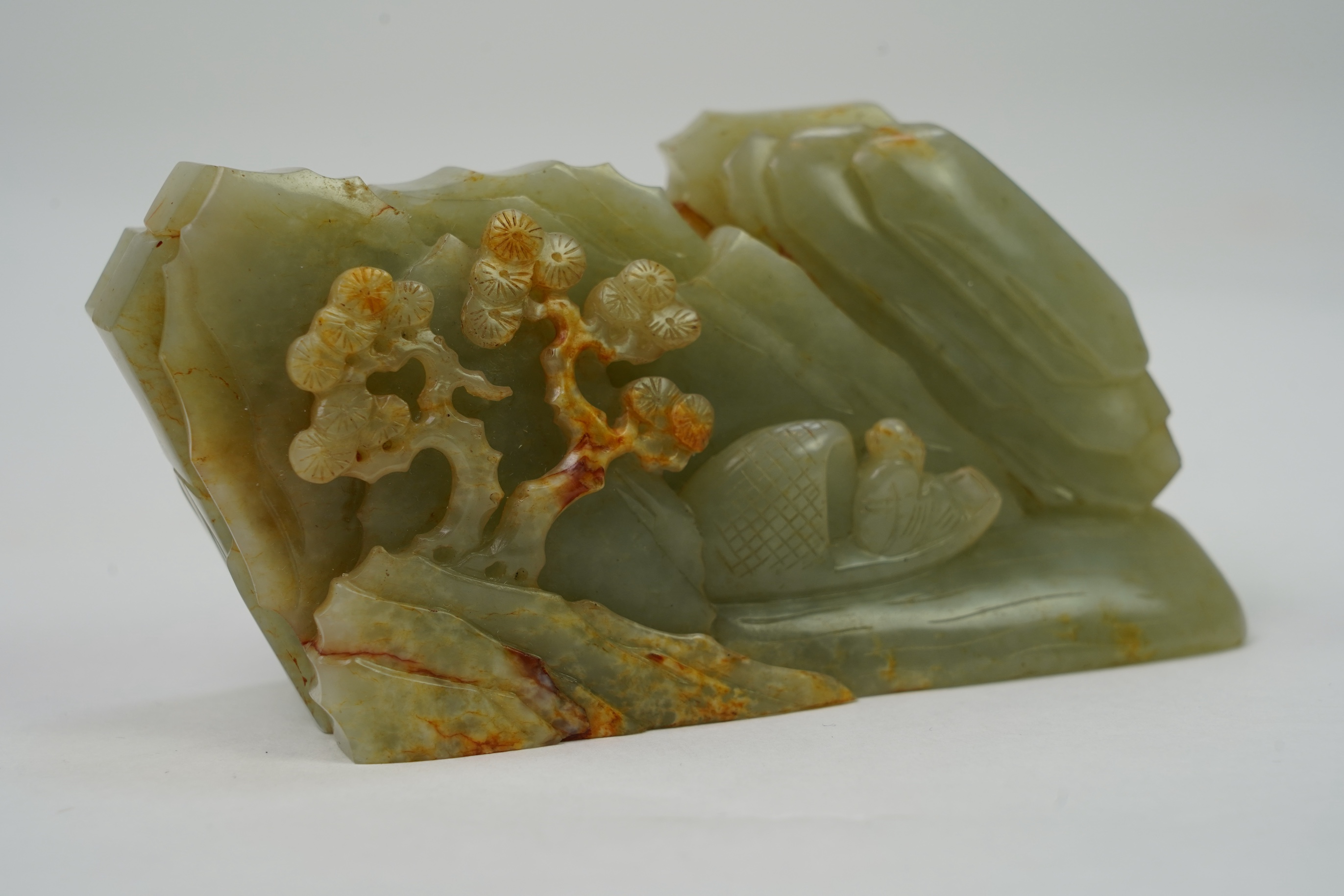 A Chinese celadon and russet jade boulder carving